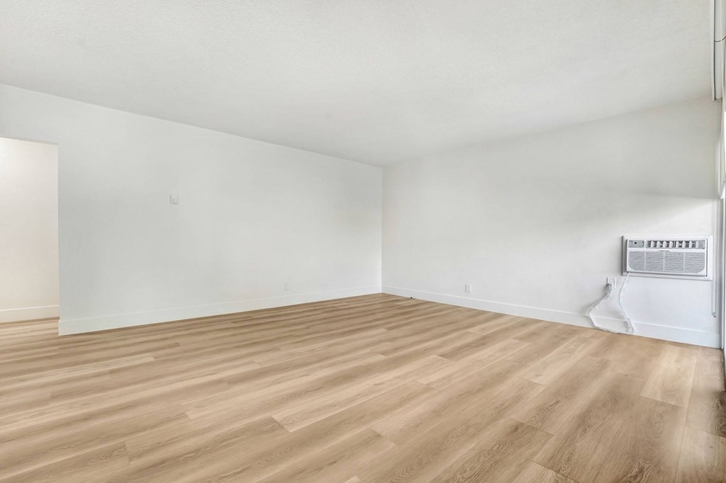 A room with wooden flooring and white walls.
