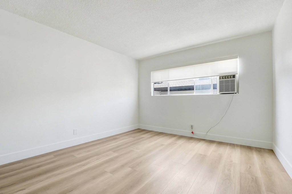 A room with a window and air conditioner unit.
