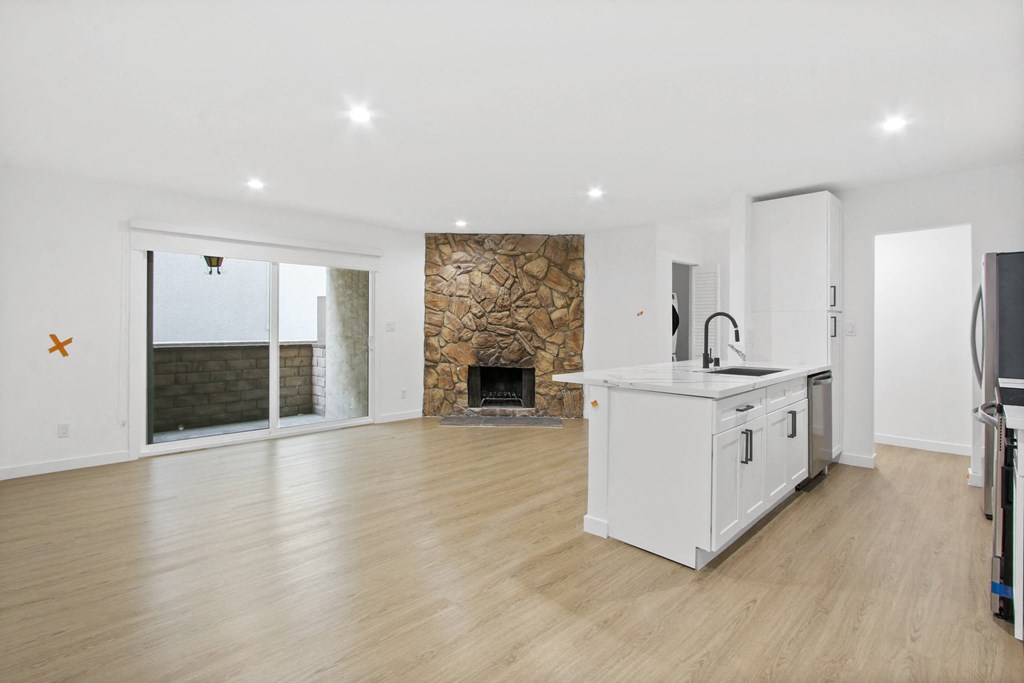 a living room with a kitchen and a fireplace
