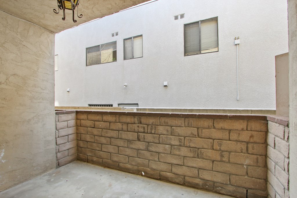 an empty room with a brick wall and a bar