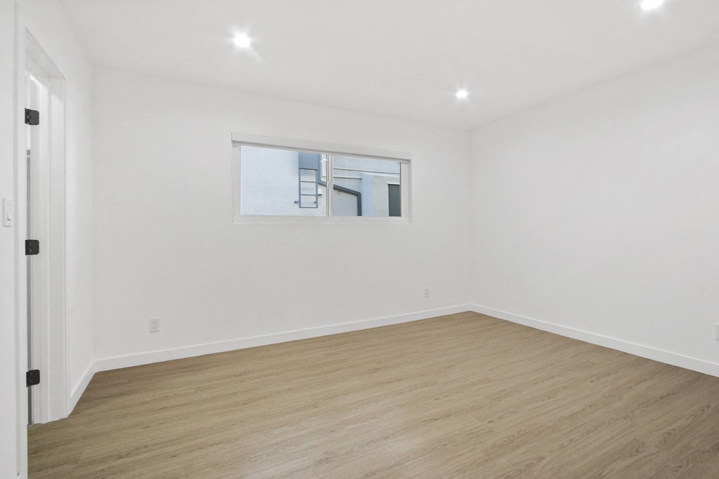 a living room with white walls and a window
