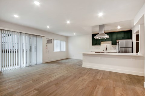 A kitchen with a white counter and wooden floors.