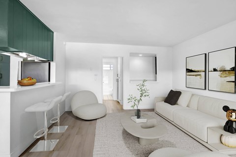 A modern living room with a white couch, a grey coffee table, and a green cabinet.