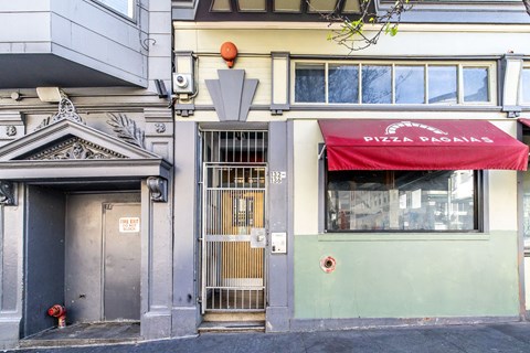 A building with a red awning that says PIZZA PAGAS.