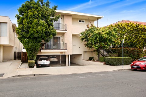 an apartment building with two cars parked in front of it