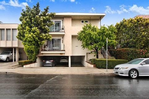 A two-story beige house with a balcony on the second floor.