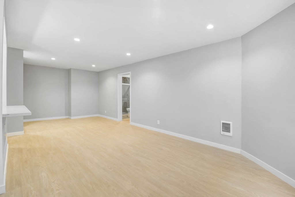 a living room with a hardwood floor and grey walls