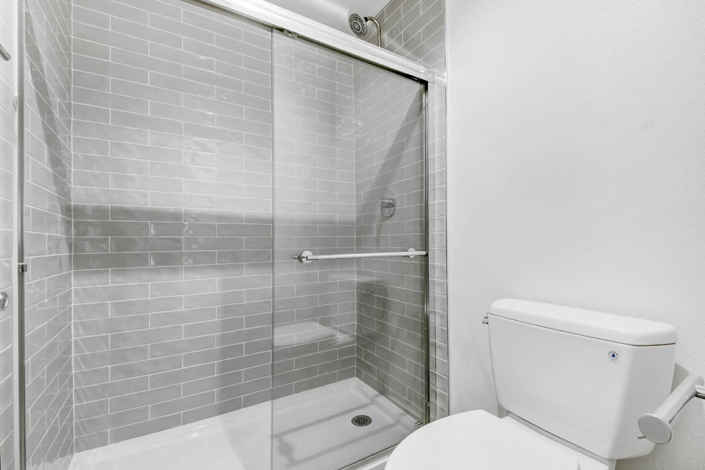a white bathroom with a shower and a toilet