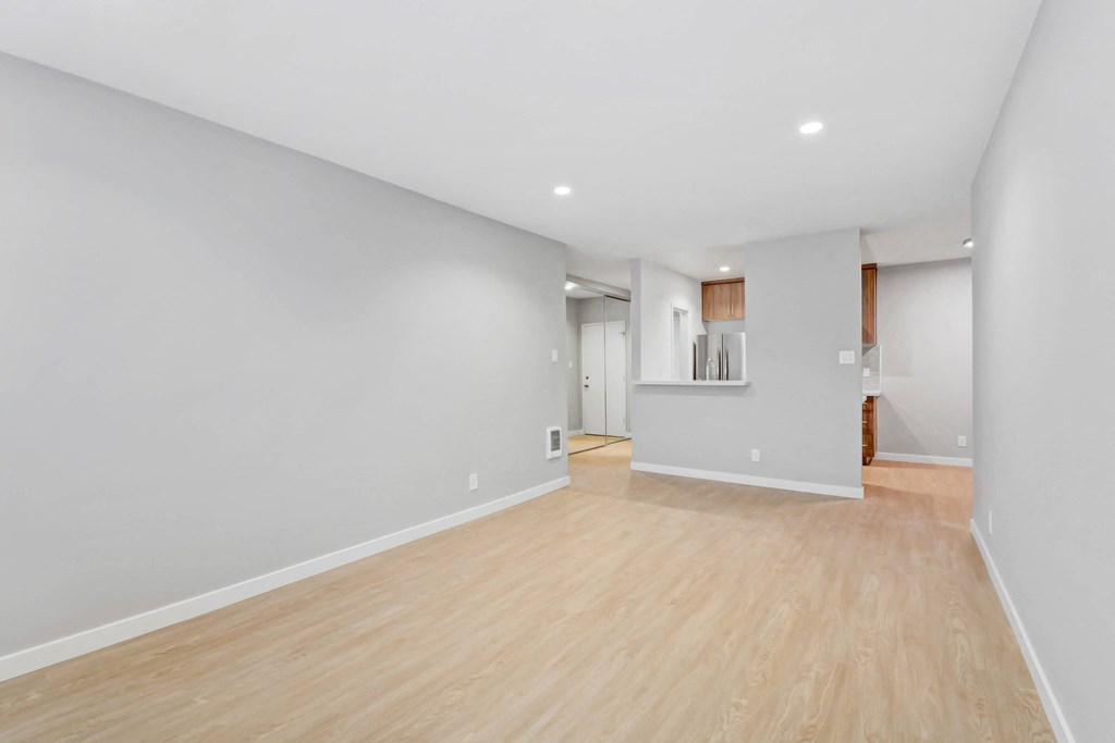 a living room with a hard wood floor and white walls
