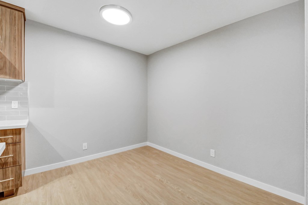 A room with wooden flooring and a cabinet with drawers.