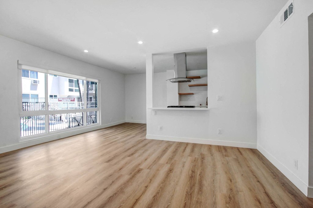 an empty living room with wood floors and a window