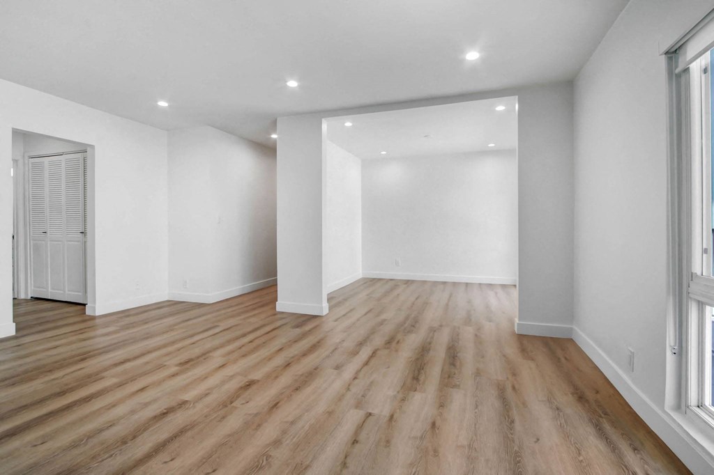 a living room with white walls and wood floors