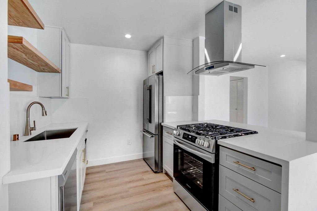 a kitchen with white cabinets and a stove and refrigerator