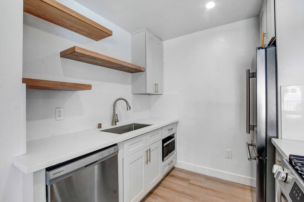 a kitchen with white cabinets and stainless steel appliances