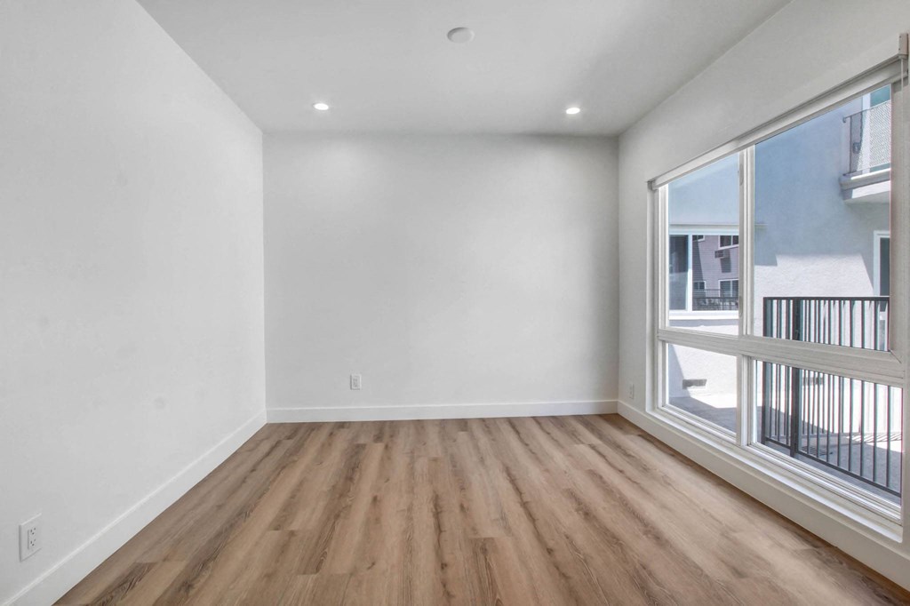 an empty living room with white walls and a large window