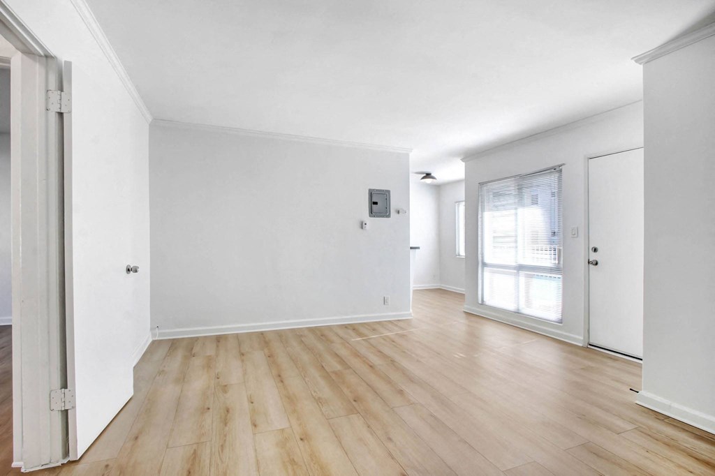 an empty living room with white walls and wood floors