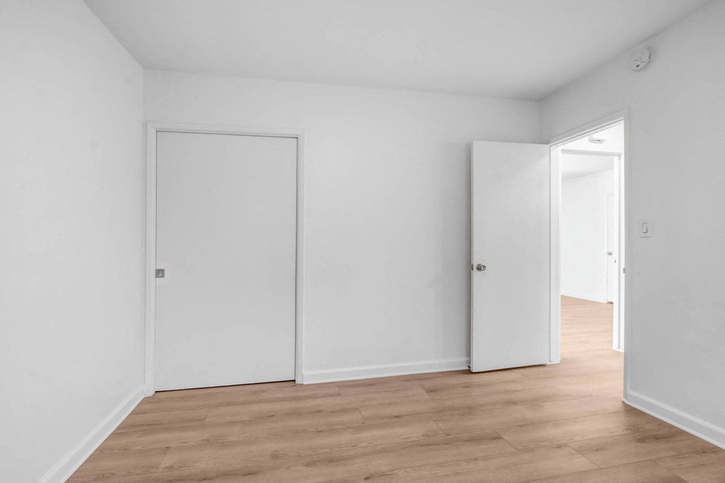 an empty room with white walls and a wood floor