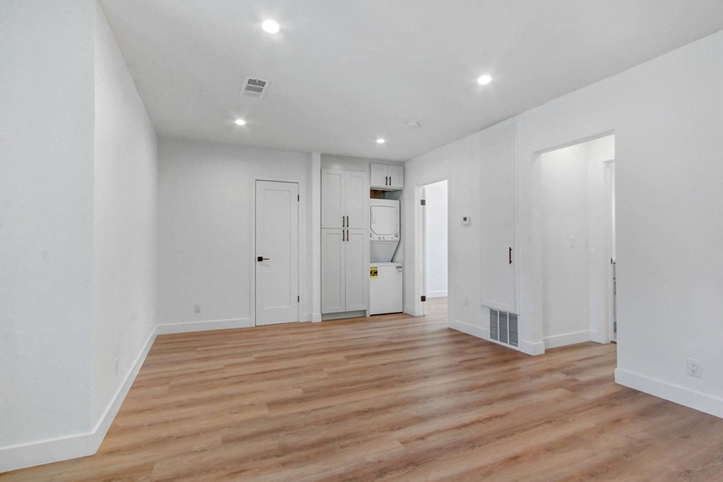 a living room with white walls and wood floors