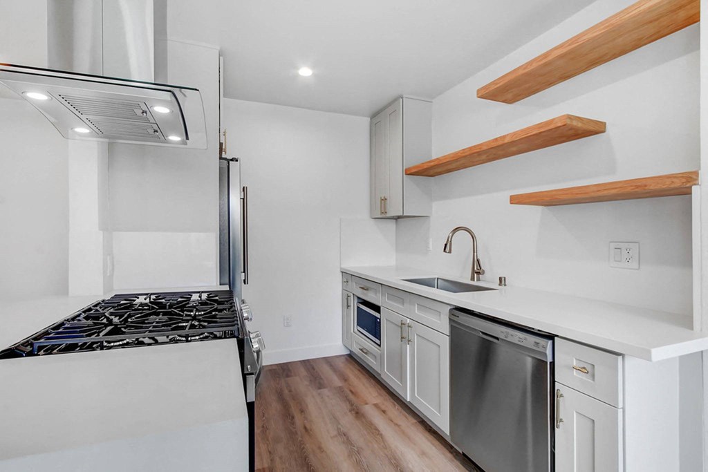 a kitchen with white cabinets and a stove and a refrigerator