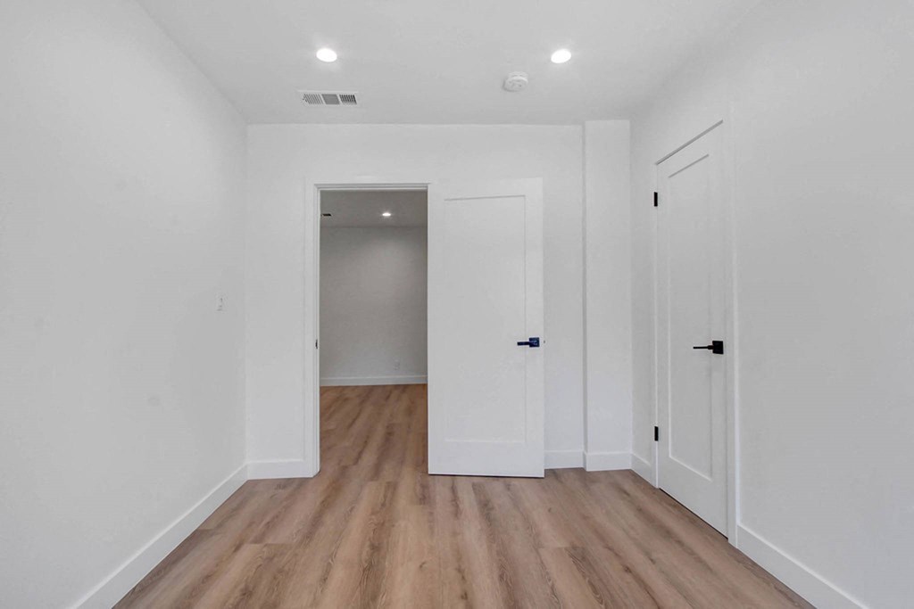 a renovated living room with white walls and wood floors