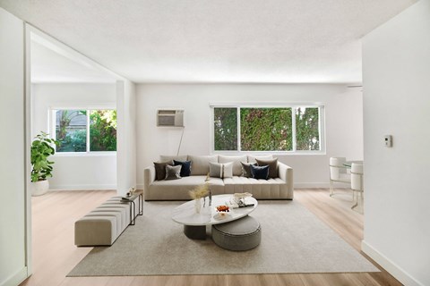 A modern living room with a large sectional sofa and a coffee table in the center.