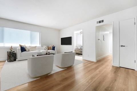 A modern living room with a white couch and a television.
