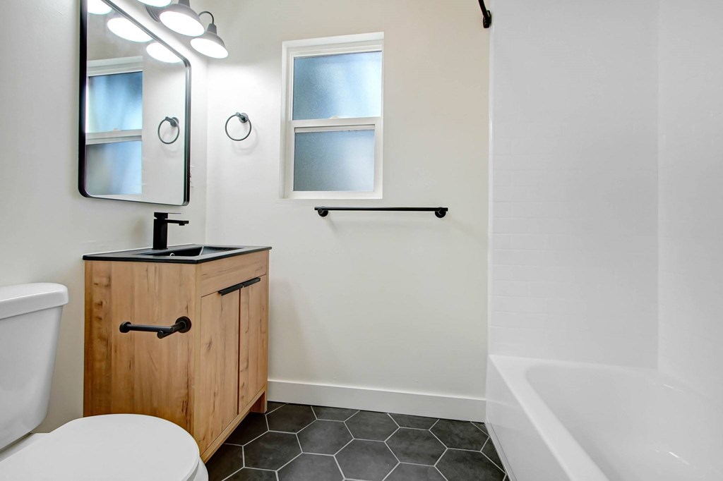 A white bathroom with a toilet, sink, and bathtub.
