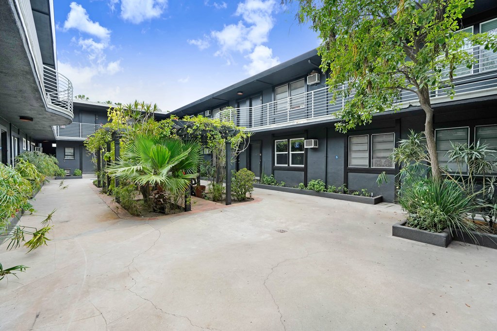 A courtyard with a concrete floor and a building in the background.