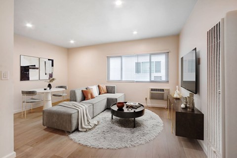 A modern living room with a grey sofa and a white coffee table.