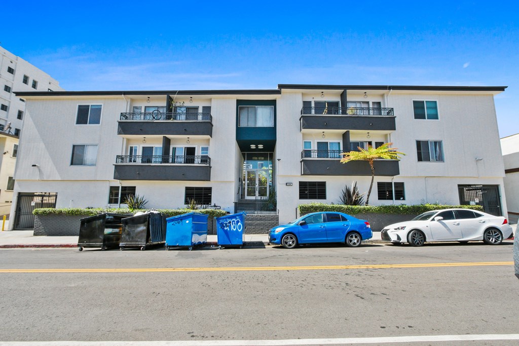 an image of an apartment building with cars parked in front