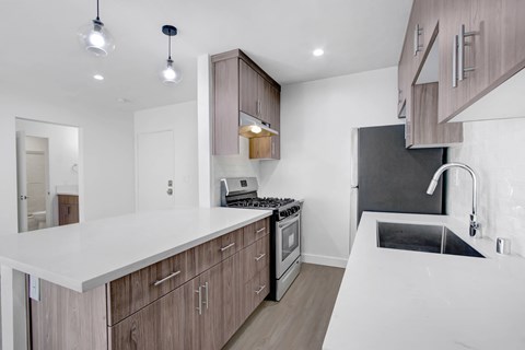 A modern kitchen with wooden cabinets and a white countertop.