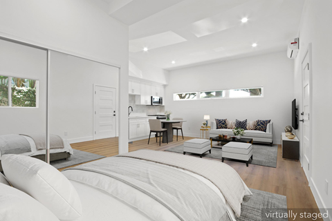 A white bedroom with a large bed and a couch.