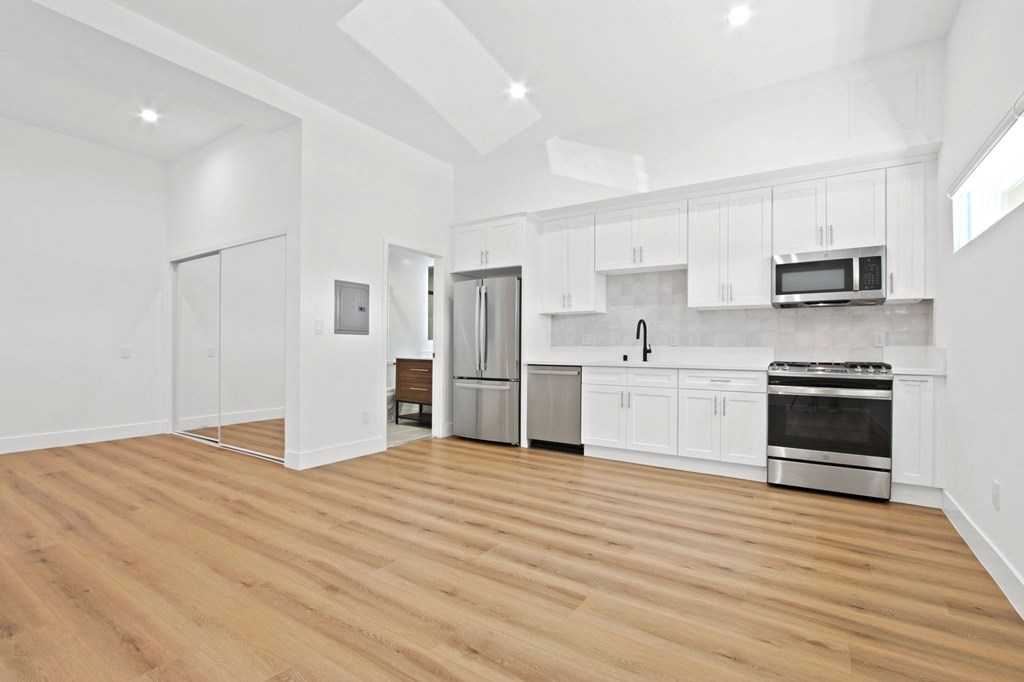 A kitchen with wooden floors and white walls.