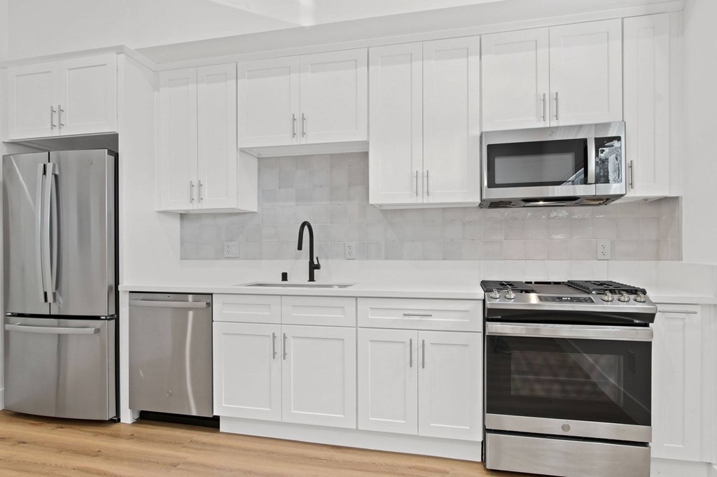 A kitchen with white cabinets and stainless steel appliances.