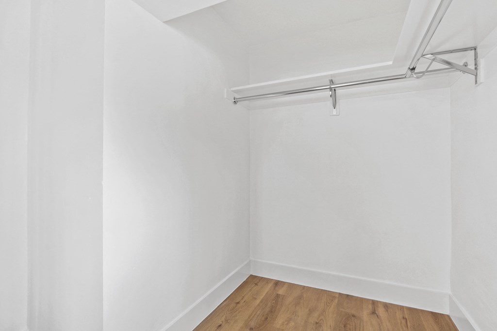 an empty room with white walls and a wood floor