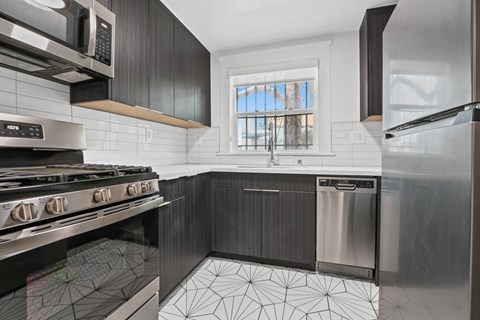 A modern kitchen with a stove top oven and a microwave above it.