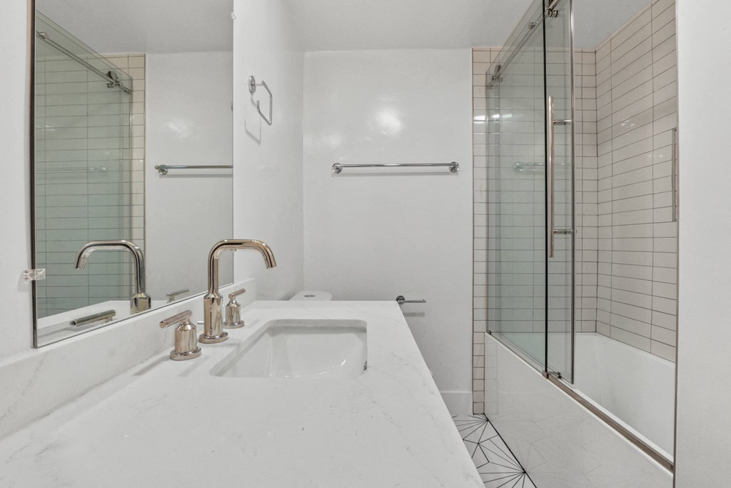 a white bathroom with a sink and a shower