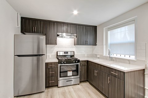 A modern kitchen with a stainless steel refrigerator and oven.