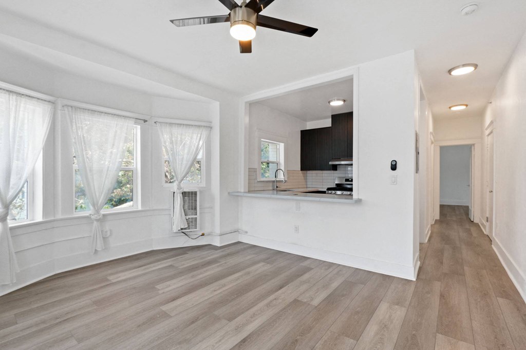 a living room with white walls and a ceiling fan