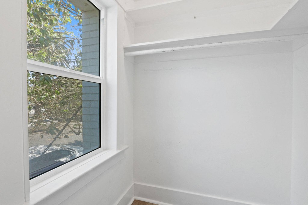 the corner of a room with a large window and white walls