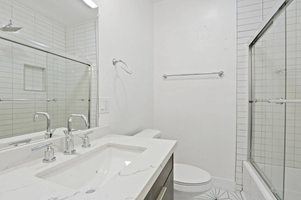 a bathroom with a sink and a shower and a toilet