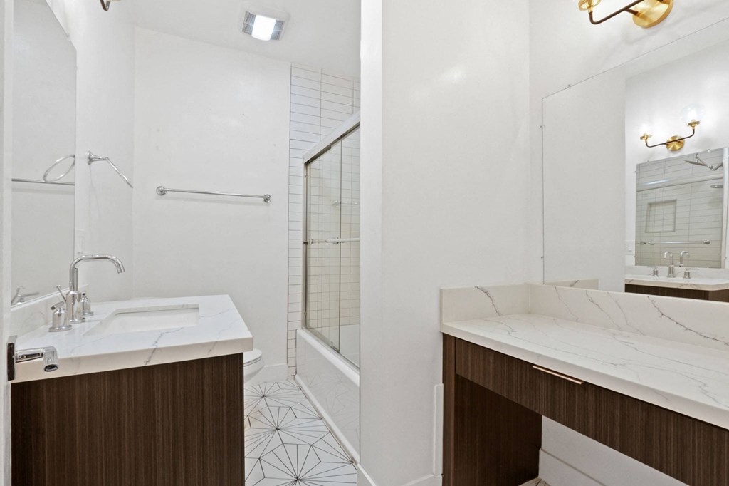 a bathroom with a sink and a shower and a mirror