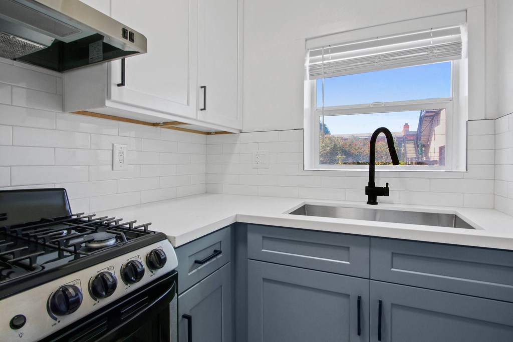 a kitchen with blue cabinets and a sink and a window