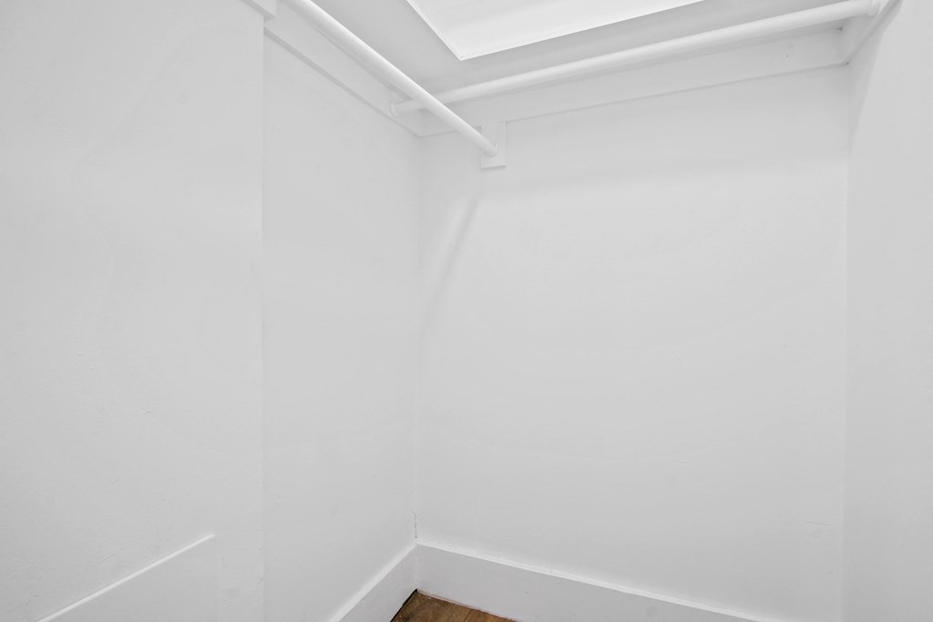 an empty room with white walls and a window