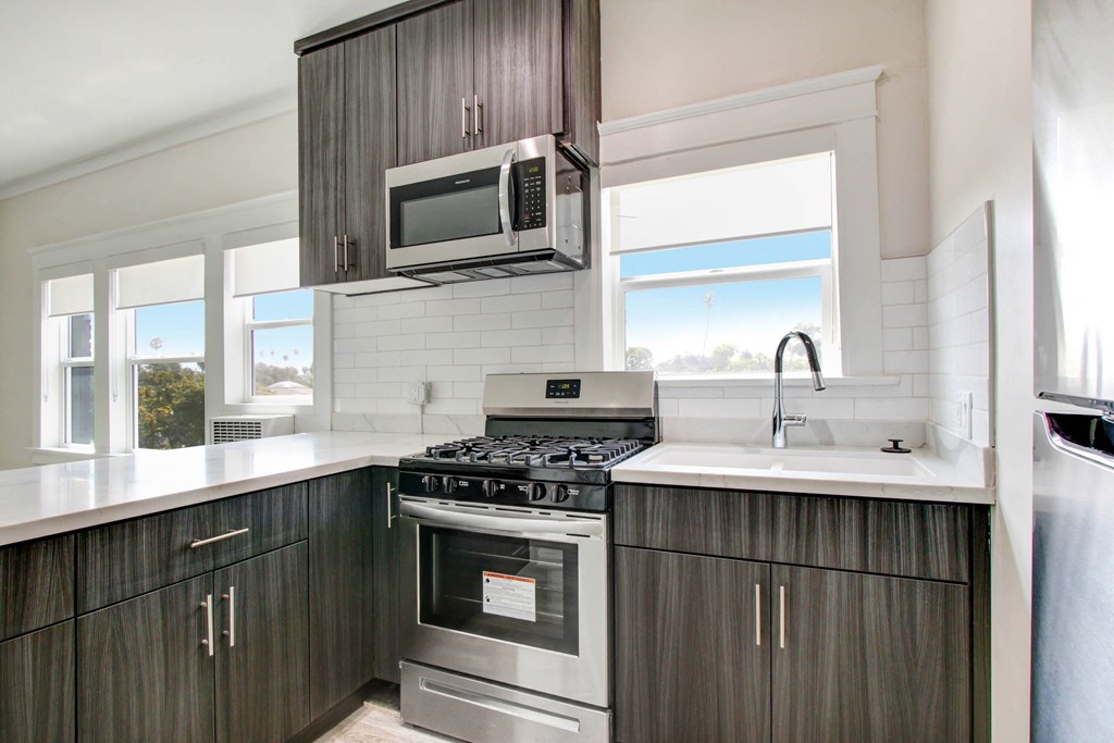 an updated kitchen with stainless steel appliances and dark wood cabinets