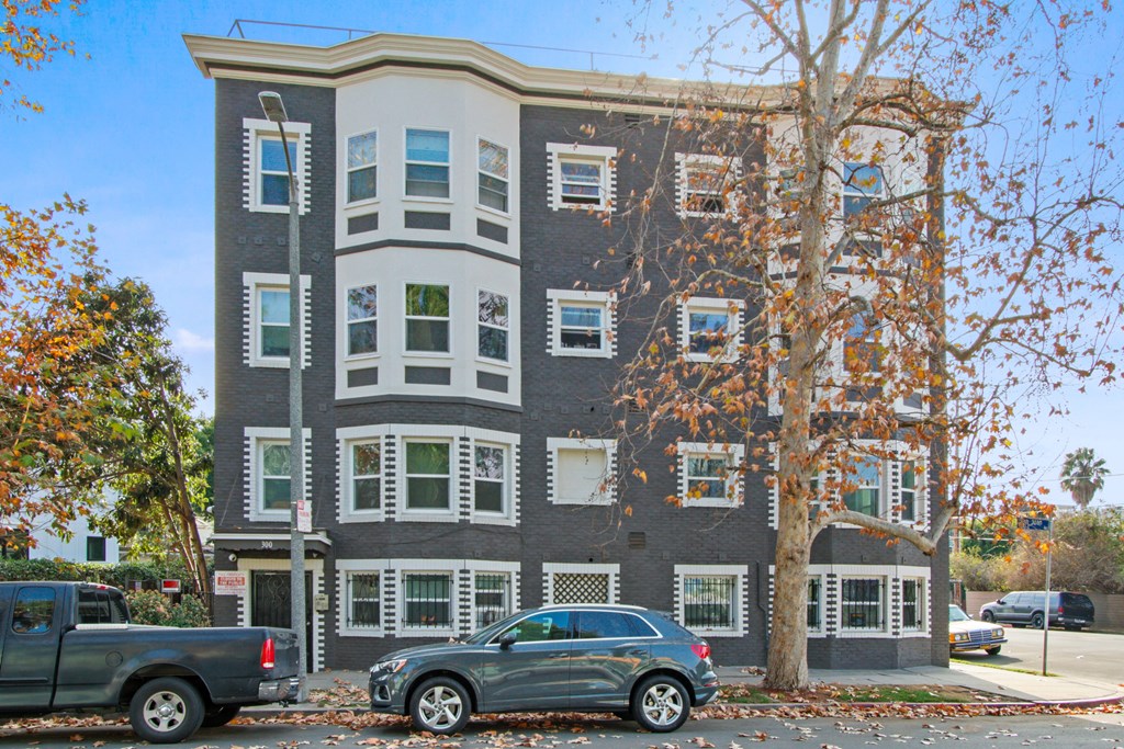 an apartment building with cars parked in front of it