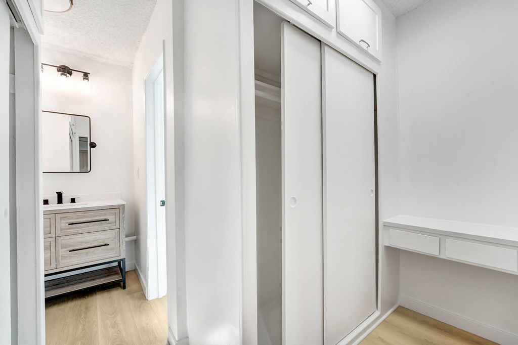 A white room with a wooden floor and a white wardrobe.