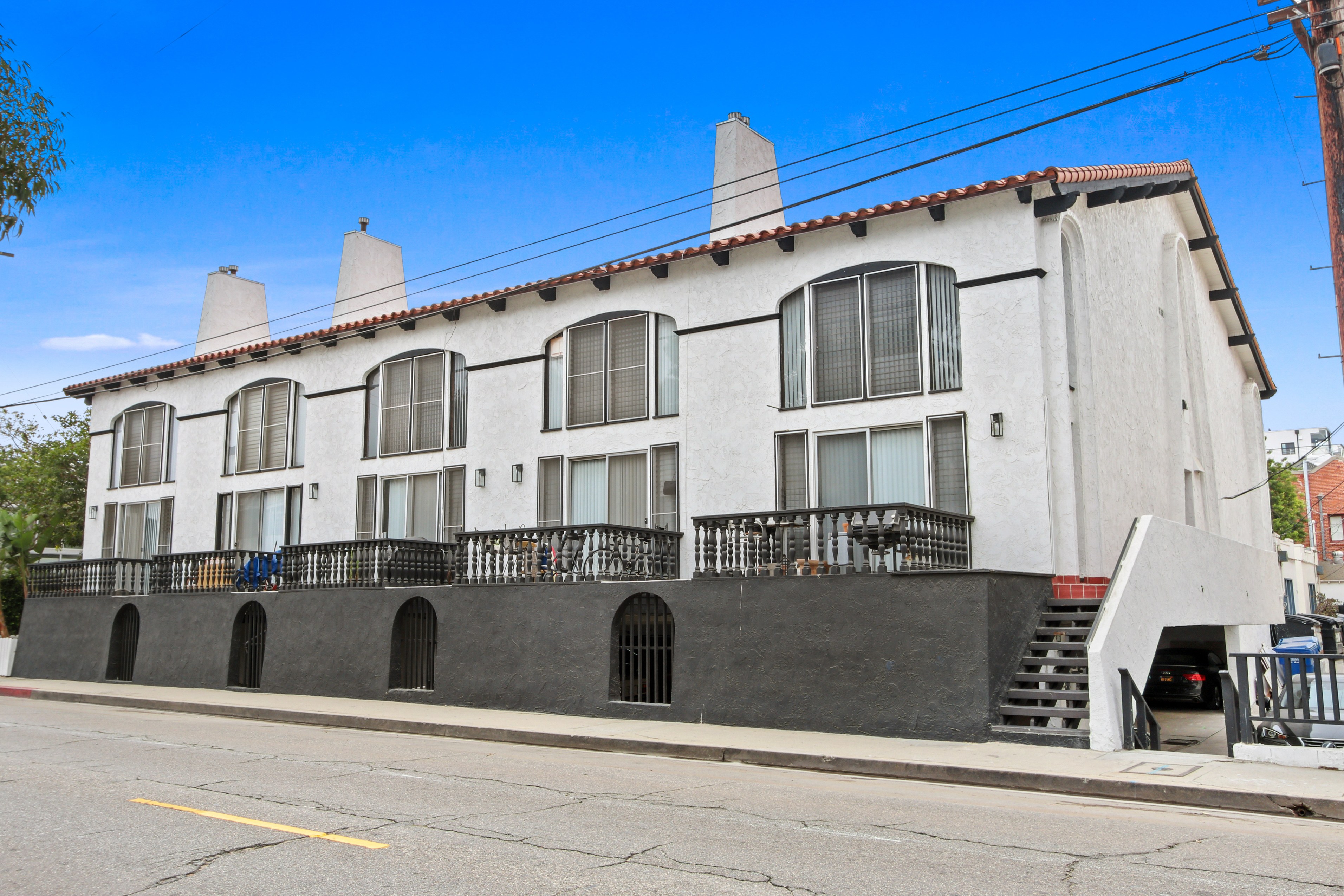 A white building with a black balcony and stairs.