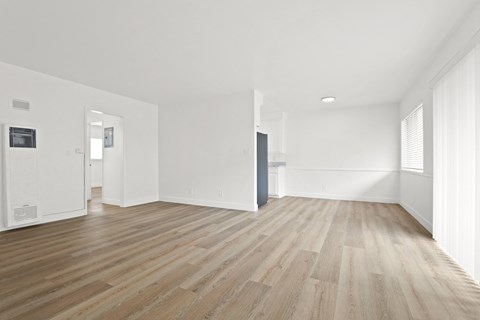 A room with wooden flooring and white walls.