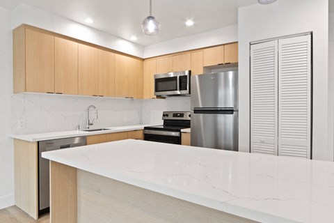 a kitchen with a marble counter top and a stainless steel refrigerator